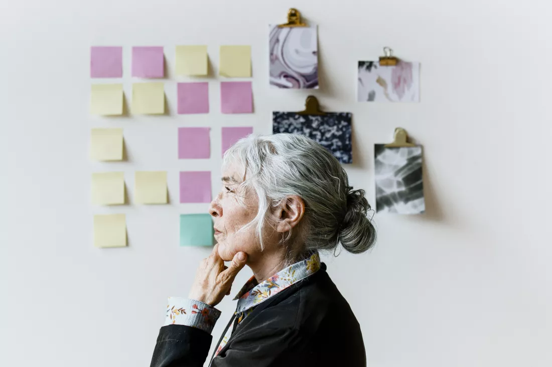 senior-businesswoman-brainstorming-ideas-wall