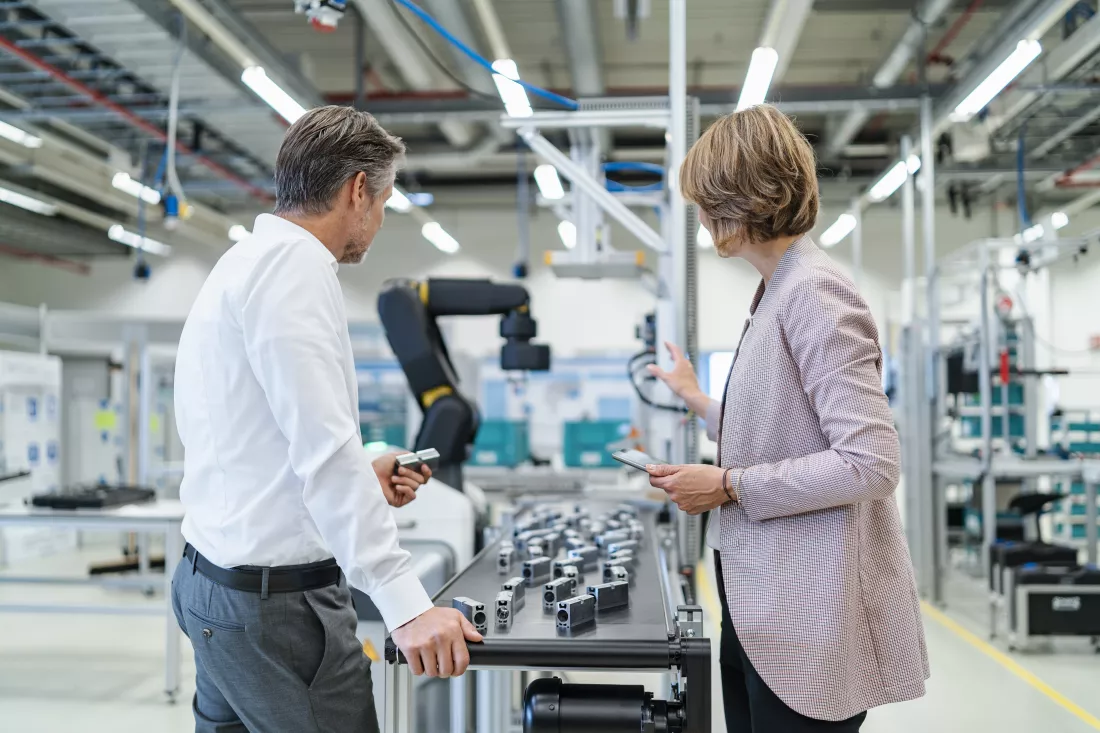 businessman-businesswoman-talking-modern-factory-hall(1)